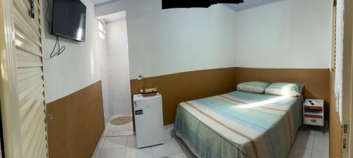 a small bedroom with a small bed and a television at Pousada e Cachoeira Paraiso in Barra do Garças