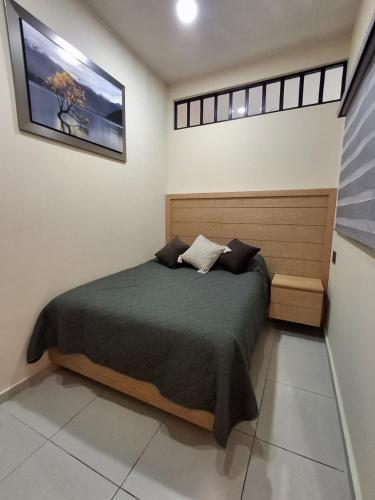 een slaapkamer met een bed in een witte kamer bij Monarca in Uruapan del Progreso