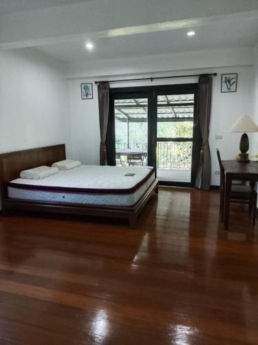 a bedroom with a bed and a wooden floor at Montana Home in Ban Pok Nai