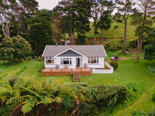 a small white house on a grassy yard at Arapawa Homestead in Picton