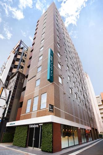 a tall building with a sign on the side of it at Sotetsu Fresa Inn Ueno-Okachimachi in Tokyo