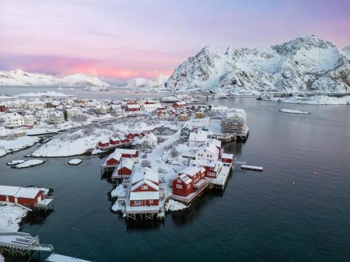 an aerial view of a harbor with snow covered mountains at Henningsvær Rorbuer in Henningsvær