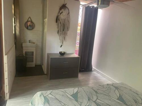 una camera da letto con un letto e una cassettiera con un uccello sul muro di Bungalow à Dumbea rivière 