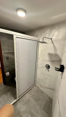 een douche met een glazen deur in een badkamer bij Hogar Kada in Tepic