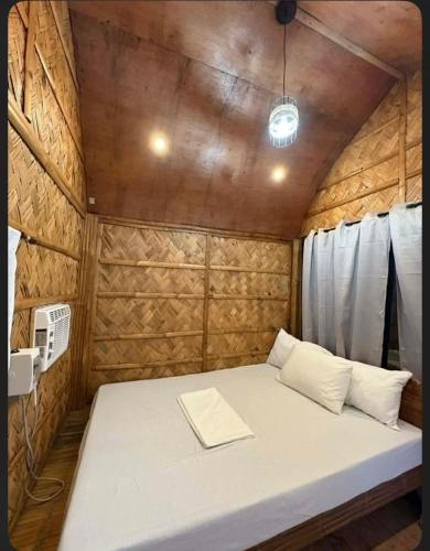 a small bedroom with a bed in a wooden room at Villa Espinoza Beach Resort Nasugbu in Nasugbu