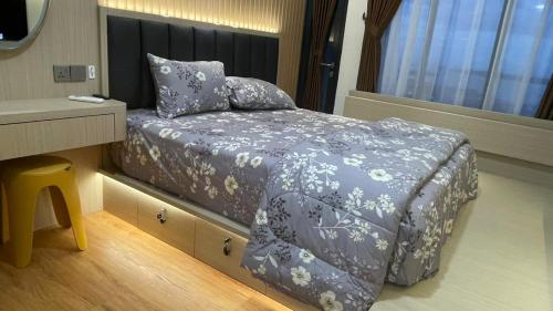a bedroom with a bed with a table and a window at Dewi's Pollux in Batam Center