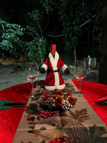 een kerstmanfiguur die op een tafel zit met twee glazen bij Pepper Trails Riverstone 