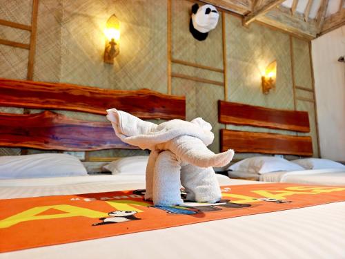 een gevulde olifant op een bed bij Panda Home in Gili Trawangan