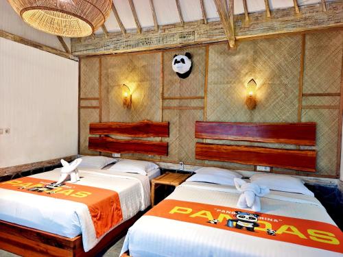 een slaapkamer met twee bedden met knuffels erop bij Panda Home in Gili Trawangan