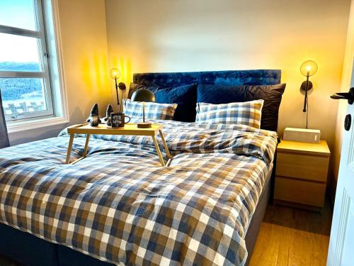 a bedroom with a bed with a table on it at Unique view! Modern apartment with sauna in Vossevangen