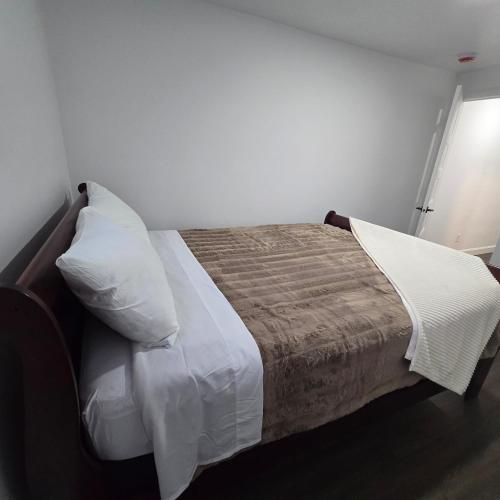 een slaapkamer met een bed met witte lakens en kussens bij Ici Chez Vous in Trois-Rivières