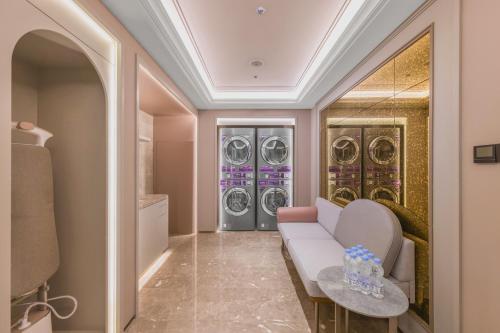 a laundry room with a couch and three washing machines at Mercure Beijing Future Science City in Beijing