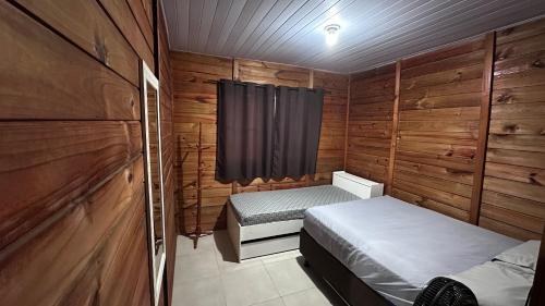 a small bedroom with two beds and a window at 900m praia, próximo Beto Carrero in Piçarras