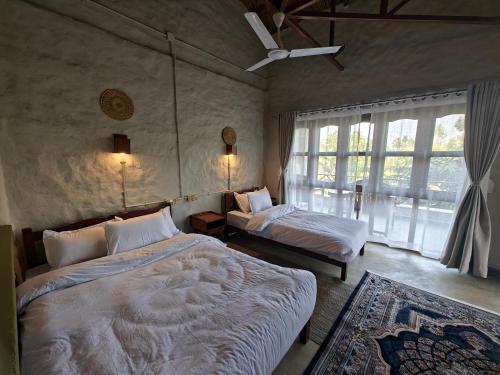 een slaapkamer met twee bedden en een raam bij Himalchuli Nature Farmstay in Bhagaura