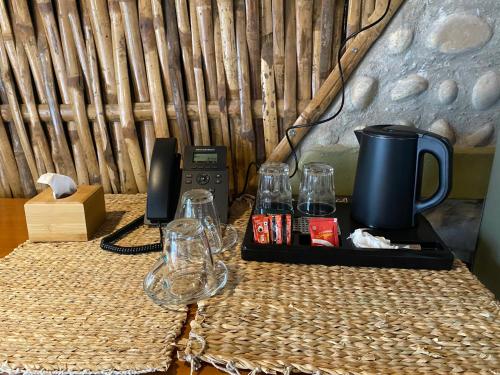 een tafel met glazen en een koffiezetapparaat. bij Himalchuli Nature Farmstay in Bhagaura