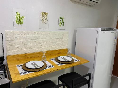 een tafel met twee borden en een koelkast in een keuken bij Studio Compac. | Shoppings | Centro | Arena | Aero in Manaus