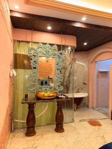 een badkamer met een tafel met een spiegel en een bad bij Satoria Villa in Jaipur