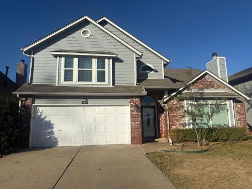 een grijs huis met een witte garage bij Emmanuel House in Tulsa
