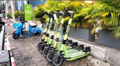 una fila di sci e scooter parcheggiati su un marciapiede di warm house chiang mai a Chiang Mai