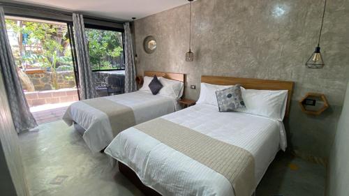 een slaapkamer met twee bedden en een raam bij Hotel Casa Grangelo in Atlixco