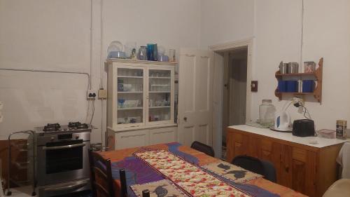 een keuken met een fornuis en een tafel erin bij The Wellstead in Wynberg