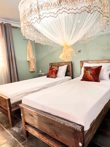 twee bedden in een kamer met twee bedden sidx sidx sidx bij Mufasha Boutique Suites in Kisoro