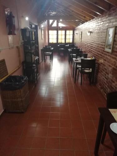 a dining room with tables and chairs and a brick wall at Hotel Lincoln in Villa Gesell
