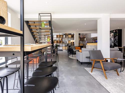 een bar met stoelen en tafels in een kamer bij ibis Dijon Sud in Perrigny-lès-Dijon