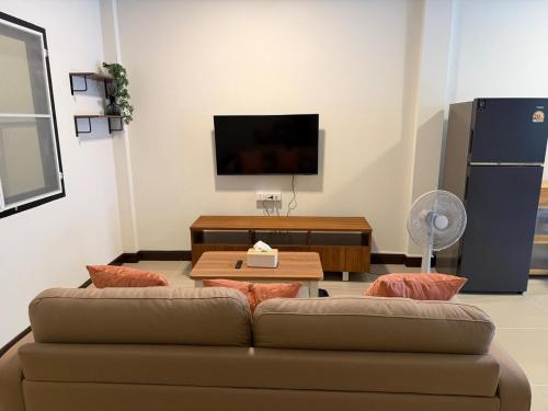 un soggiorno con divano e TV a schermo piatto di Baan Airport 2 a Ban Wat Pho Thong