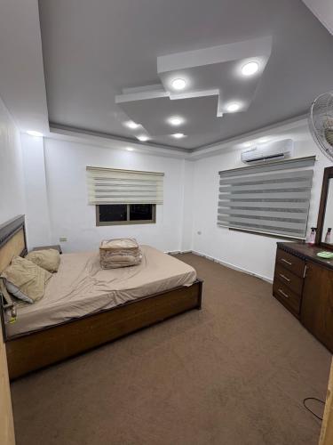 a bedroom with a large bed and a window at Golden Stay in Jerash