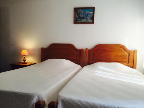 2 Betten in einem Schlafzimmer mit einem Bild an der Wand in der Unterkunft Residencias Varadouro in Varadouro