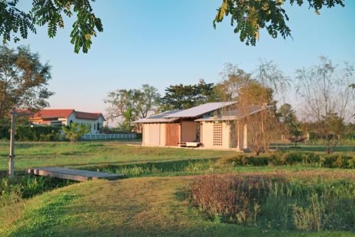 ein kleines Gebäude in der Mitte eines Feldes in der Unterkunft Rimtai Hütte in Mae Rim