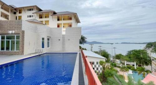 ein Bild eines Swimmingpools vor einem Gebäude in der Unterkunft Royal Hill Satun Hotel in Ban Pak Ba Ra