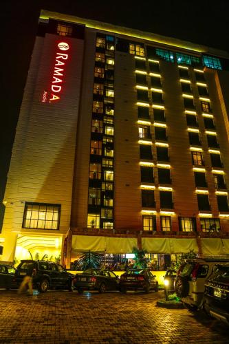 a tall building with cars parked in front of it at Ramada Addis, Addis Ababa in Addis Ababa