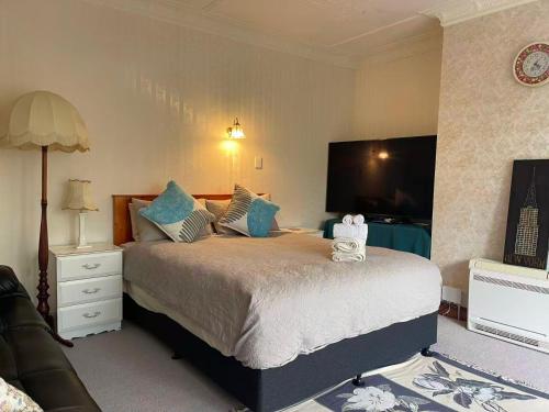 a bedroom with a large bed with blue pillows at The southernmost home in the world in Invercargill