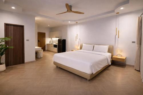 een slaapkamer met een groot wit bed en een badkamer bij The Escape Kamala in Kamala Beach