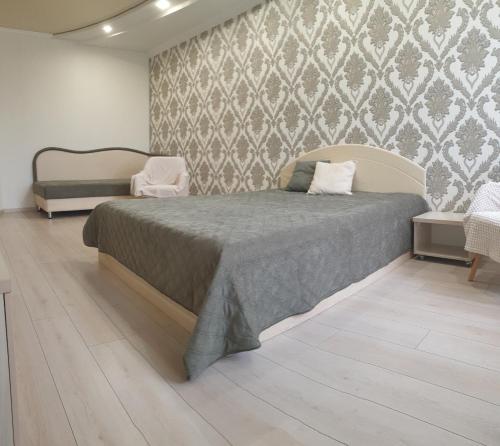 a bedroom with a bed and a wall at Видові апартаменти на пляжі in Cherkasy
