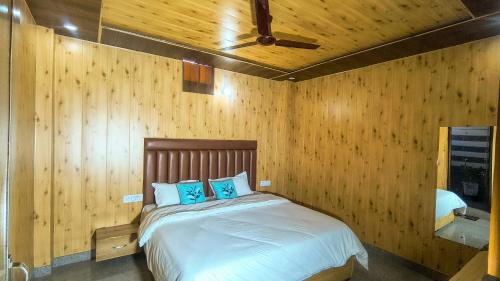 een slaapkamer met een bed in een houten wand bij Oak sunlight Restaurant & Provides Famous Gadwali food in Mussoorie