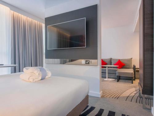 a hotel room with a bed with a flat screen tv at Novotel York Centre in York