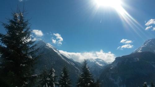 a view of a mountain range with the sun in the sky at Haus am Sonnenhang in Finkenberg