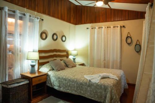 a bedroom with a bed and a lamp and a window at Casa Vegas Panoramic Views near Monteverde in Turín