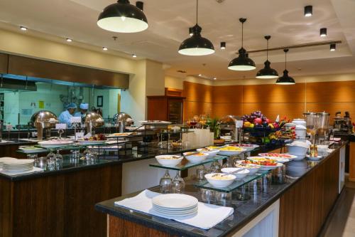 a buffet line in a restaurant with plates and food at Ramada Addis, Addis Ababa in Addis Ababa