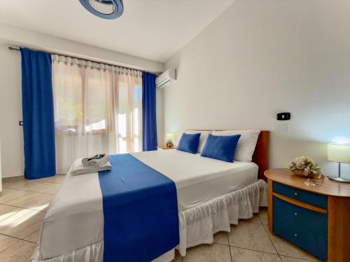 ein Schlafzimmer mit einem großen Bett mit blau-weißer Bettwäsche in der Unterkunft Villa Ruffilli in Benevento