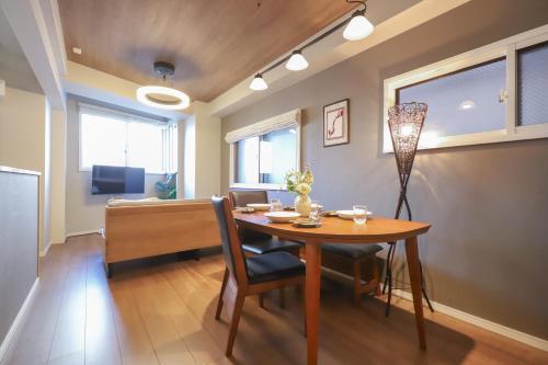 a dining room with a table and a desk at Omotenashi House Kawaguchi in Kawaguchi