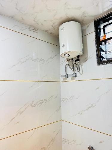 a white marble bathroom with a light on the wall at Sairam Residency in Ellora