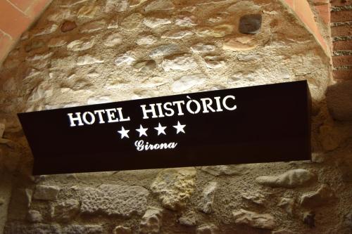 
a sign on a wall in a foreign language at Hotel Històric in Girona
