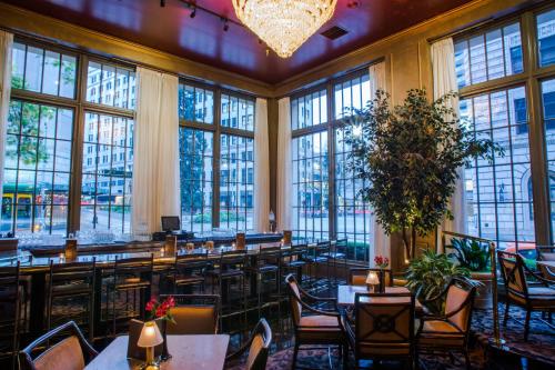 un restaurante con mesas, sillas y ventanas grandes en Mayflower Park Hotel, en Seattle