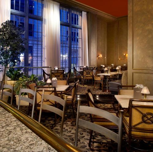 a restaurant with tables and chairs and windows at Mayflower Park Hotel in Seattle