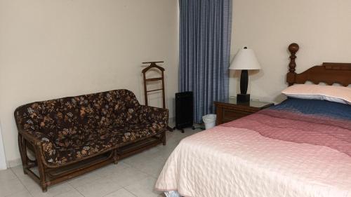 维多利亚城Casa Cd Victoria 1V的一间卧室配有一张床、一把椅子和一盏灯