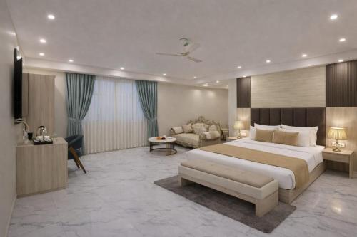 een slaapkamer met een groot bed en een bank bij Hotel East End Delhi Airport With Free Airport Drop in New Delhi